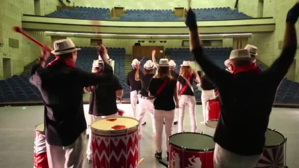 Tył muzycznej grupy trzynastu osób w kapeluszach grając na perkusji — Wideo stockowe