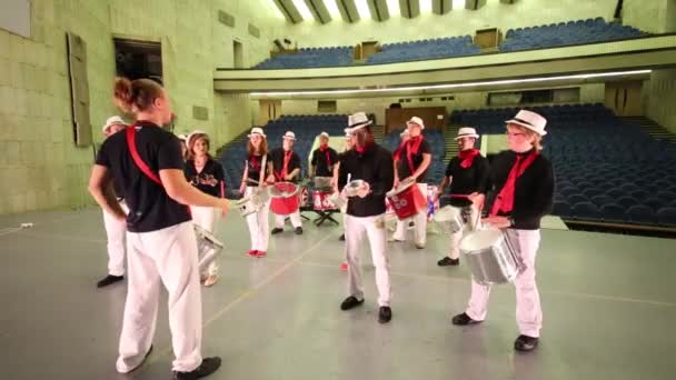 Kelompok musik dari empat belas orang bertopi dengan pemimpin memainkan drum — Stok Video