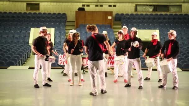 Muzikale groep van veertien mensen met leider drummen op het podium — Stockvideo