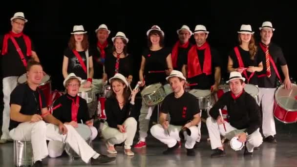 Музыкальная группа из четырнадцати человек в шляпах играет на барабанах и позирует — стоковое видео