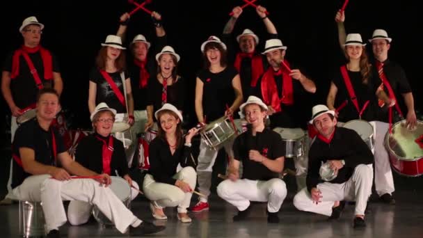 Musical group of fourteen people with drums pose and wave hands — Stock Video