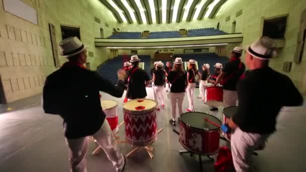 Vierzehnköpfige Musikgruppe mit Hüten trommelt — Stockvideo