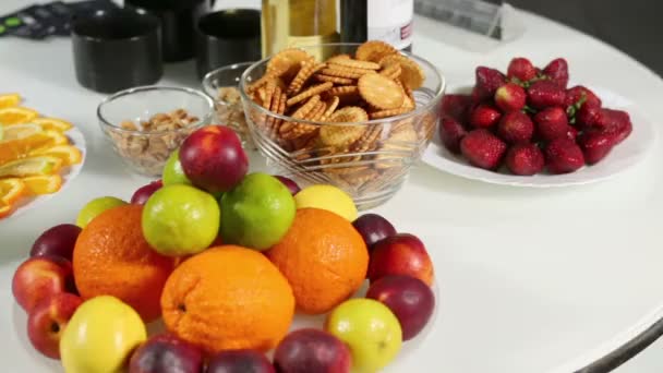 Plats pleins de fruits, vases avec biscuits et noix, boissons — Video