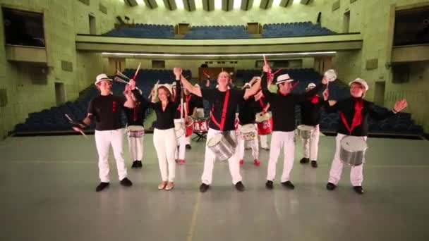 무대에서 활을 들고 있는 14명의 젊은이들의 뮤지컬 그룹 — 비디오