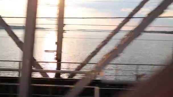 Railroad on bridge, river and sunsetwindow of moving passenger train — Stock Video