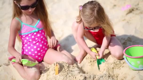 Små flickor sitta på stranden — Stockvideo