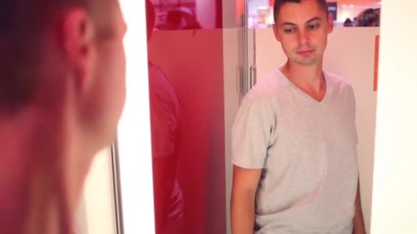 Young man tries on t-shirt — Stock Video