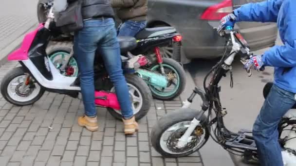Группа подростков на разных скутерах на городской улице . — стоковое видео