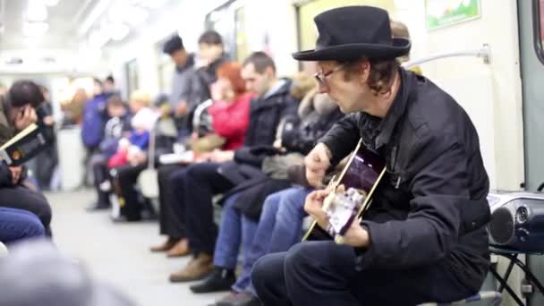 Musician in the subway carriage. — Stock Video