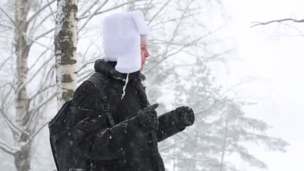 En man i en vit mössa med öronlappar — Stockvideo