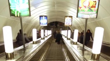 İnsanlar metroda yürüyen merdivene çıkar ve inerler..