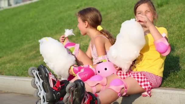 Две девушки едят сладкую нитку — стоковое видео