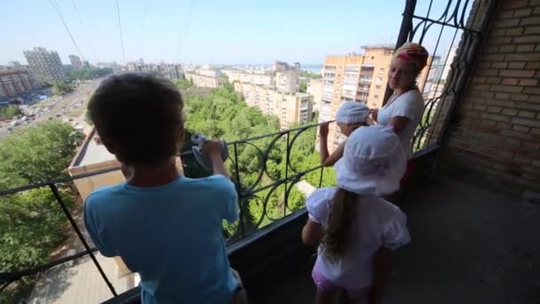 Madre con niños de pie en el balcón — Vídeo de stock