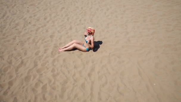 Mulher encontra-se na areia — Vídeo de Stock