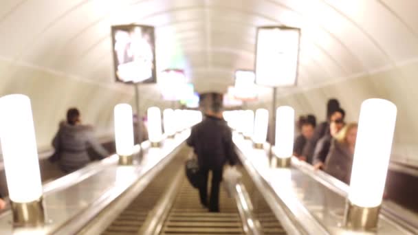 Människor stiger upp och ner på rulltrappan vid tunnelbanan, inte i fokus. — Stockvideo