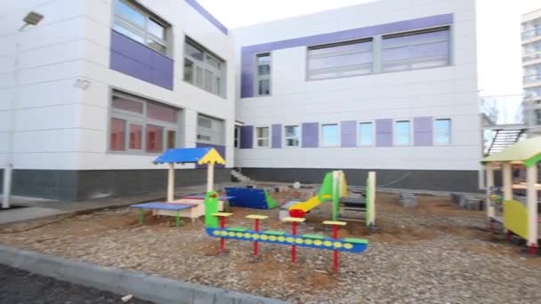 Детская площадка возле нового детского сада — стоковое видео