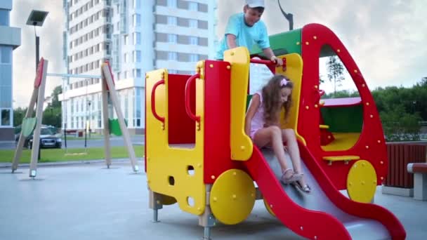 Crianças deslizam no parque infantil — Vídeo de Stock