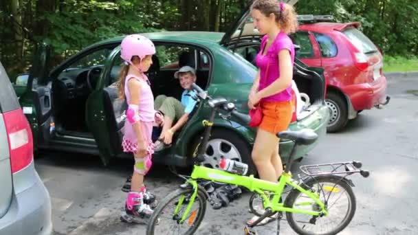 Família se prepara para andar de bicicleta e rolos — Vídeo de Stock