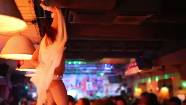 Beautiful woman in angel costume dances on bar in night club — Stock Video