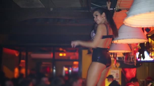 Молодая женщина в черном костюме танцует в баре в ночном клубе — стоковое видео