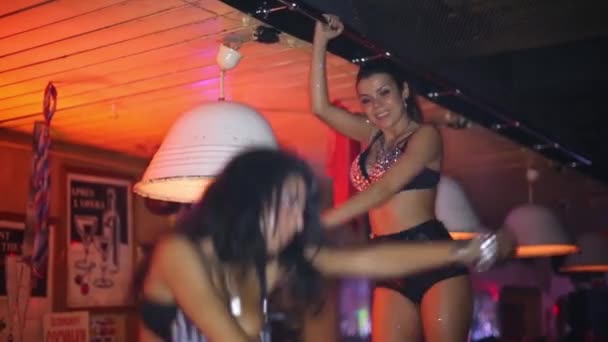 Deux belles femmes en costumes noirs dansent au bar à thème . — Video