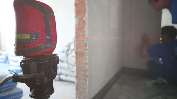 Three workers make measurements with laser level tool — Stock Video