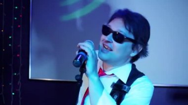 Adam gitar çalıyor ve şarkı söylüyor