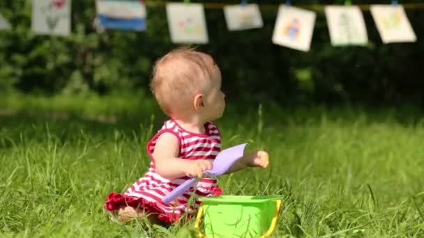 Baby speelt met schop en emmer — Stockvideo