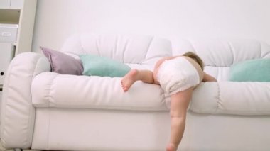 Evde beyaz kanepeden bebek bezi ne kadar tırmanan çocuğun arkası