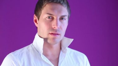 Stand-up yakalı Beyaz tişörtlü genç adam kameraya poz veriyor..
