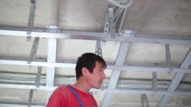 Üniformalı erkeklere yüklemek framework asılı tavan için tornavida tarafından