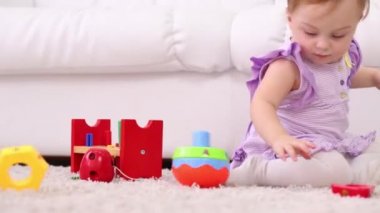 Küçük sevimli kız düşünme gelişimi için oyuncak ile oynar