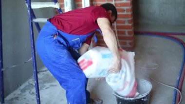 Alçı duvar için beton harç hazırlayan işçinin bacakları