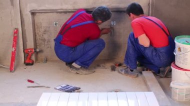 İşçi çelik dirsek pozisyonu duvardaki çekiç tarafından hizalar..