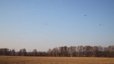 Üç siyah helikopter kuru otile alan üzerinde gökyüzünde sinek
