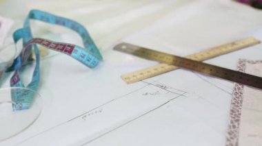 Sarışın kadın terzi kalem ve cetvel ile desenler çizer