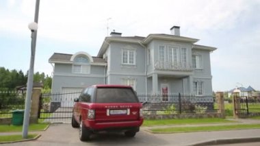 Yaz gününde modern iki katlı yazlık ve kırmızı araba