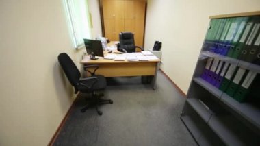 Geniş çalışma masası ve yumuşak koltuklar ile küçük bir ofis