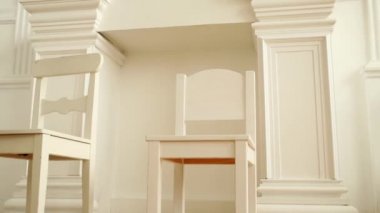 İki küçük ahşap sandalye şömineli beyaz oda aydınlatmalı bulunmaktadır