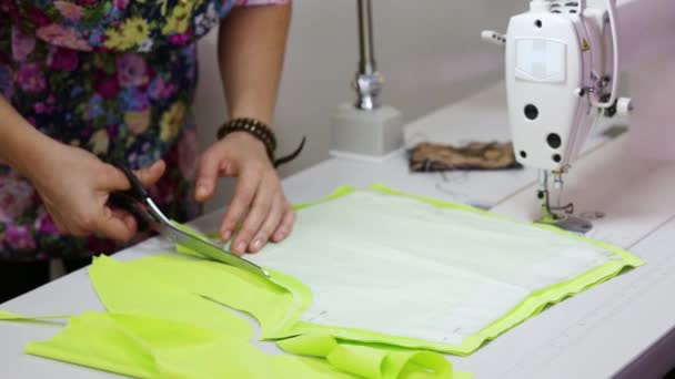 Θηλυκό ράφτης χέρια κοπή ελαφρύ πράσινο ύφασμα στο τραπέζι — Αρχείο Βίντεο