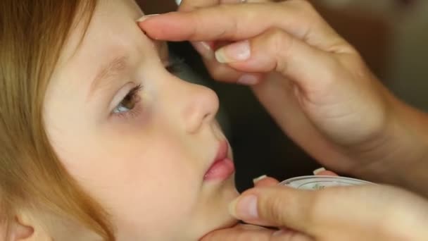 女性は少女の額に小さなラインス トーンをスティックします。 — ストック動画