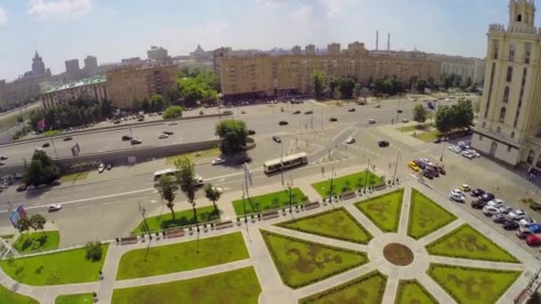 Вуличний трафік біля площі з ландшафтним дизайном влітку — стокове відео