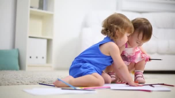 Dos niños pequeños dibujan con lápices en el suelo en la habitación en casa — Vídeos de Stock