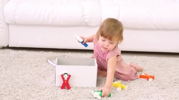 Niña juega con caja y acróbatas niños juguete — Vídeo de stock