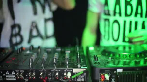 Hands of DJ guy and girl standing behind machine in night club — Stock Video