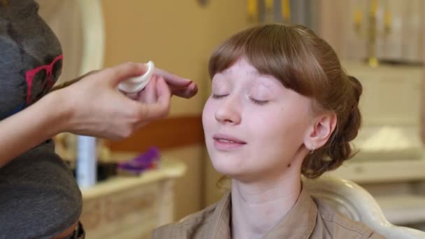 Make-up van de toepassing van de handen make-up artiest op gelukkig mooi meisje — Stockvideo