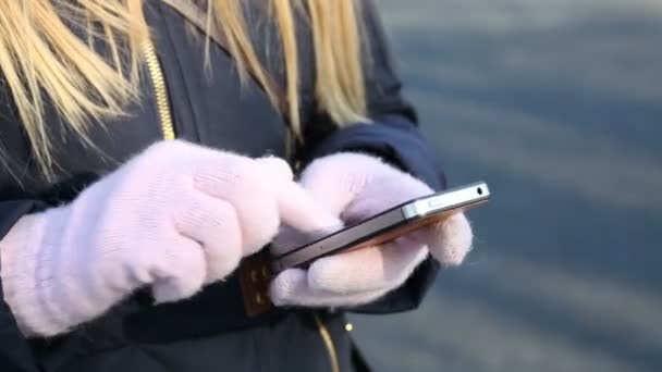 Las manos de la mujer guantes calientes pantalla táctil del teléfono táctil al aire libre — Vídeos de Stock