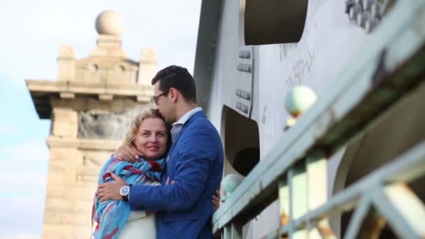 Woman in white and young man embrace and kiss on railway bridge — ストック動画