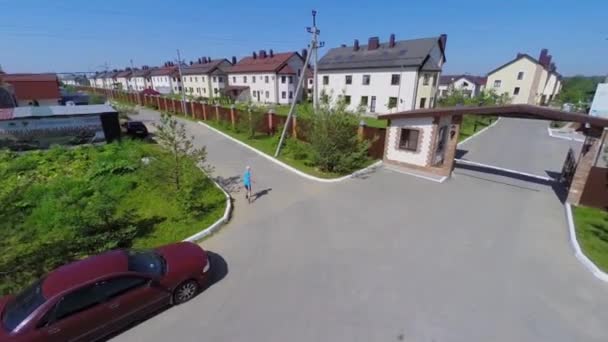 Jongen wandelingen in de buurt van toegangspoort van de huisjes stad Pushkin Lake — Stockvideo