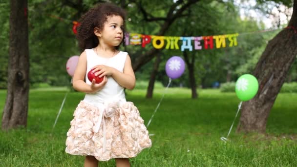 Niña lanza manzana delante de la inscripción Feliz cumpleaños — Vídeos de Stock